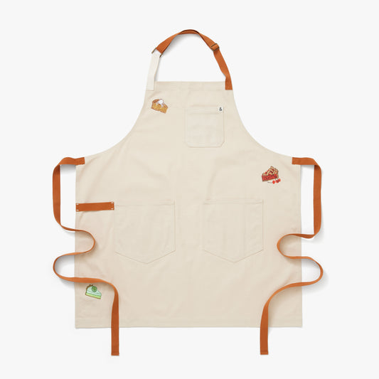 Flat white colored apron with brown straps featuring Cherry, Key Lime, and Apple pie à la mode embroidery