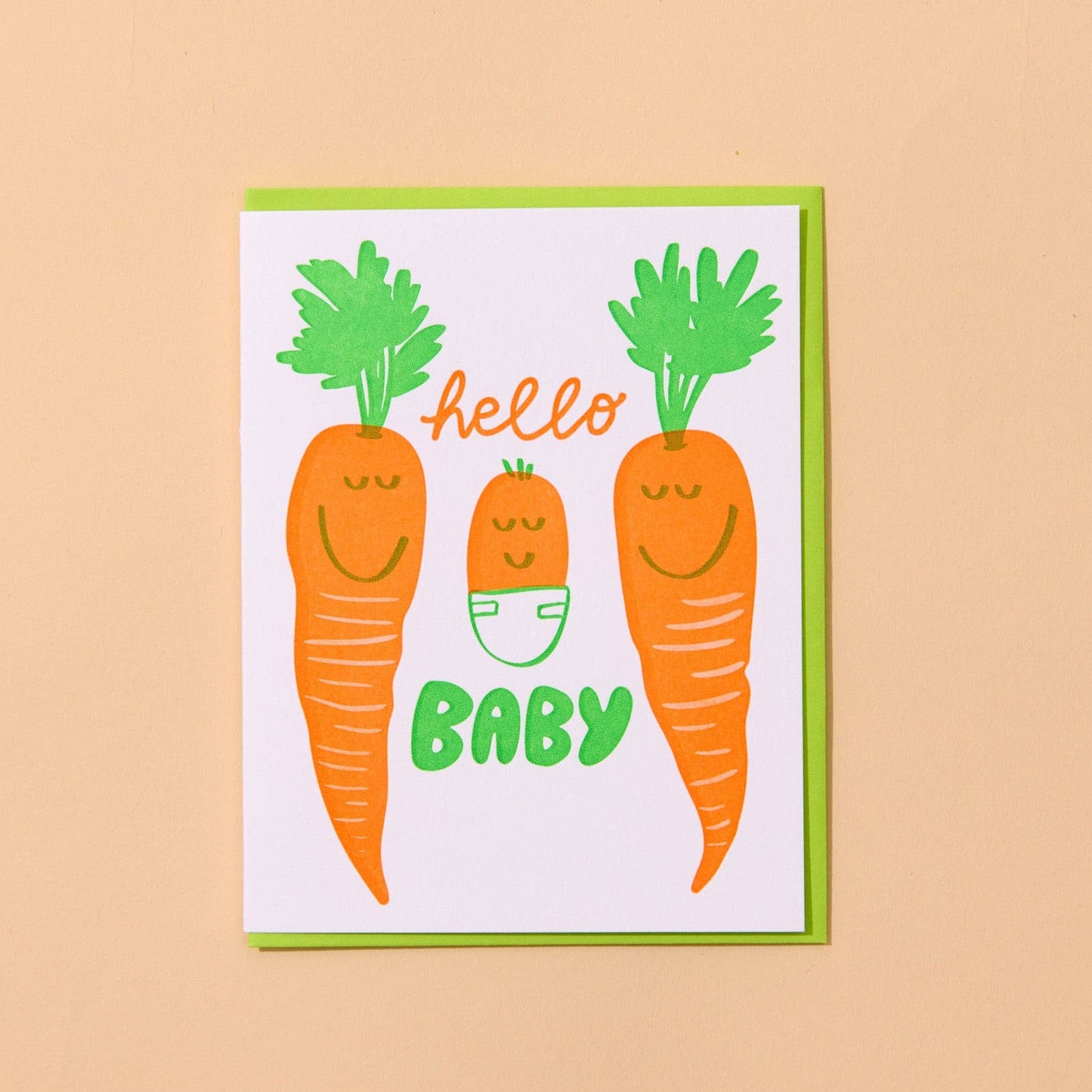 Card with cartoon carrots, 2 regular and one baby, and text 'hello baby' on a beige background