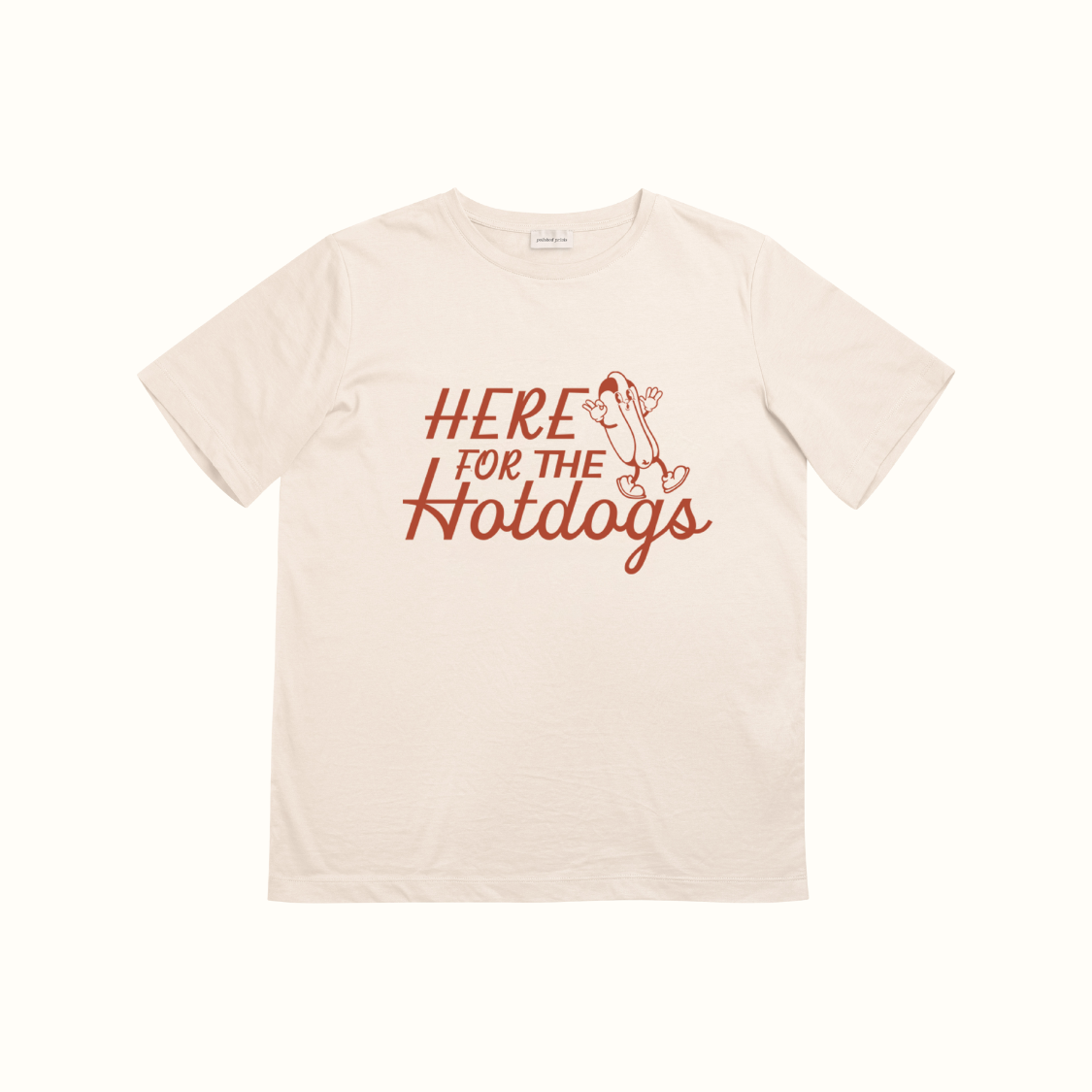 Beige t-shirt with 'Here for the Hotdogs' text and graphic on a white background