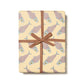 Gift wrap with herring fish pattern and brown ribbon on a white background