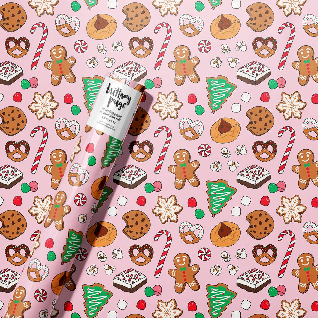 Wrapping paper roll with a pink background and Christmas-themed cookies and candies.