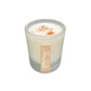 White candle in frosted glass with a sprinkle of cinnamon on top, labeled with "Horchata" on a white background