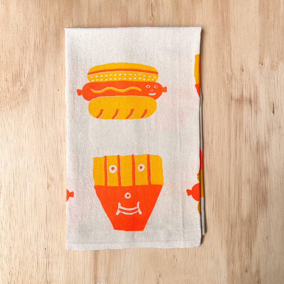 Kitchen towel with hot dog and french fry design on a wooden surface
