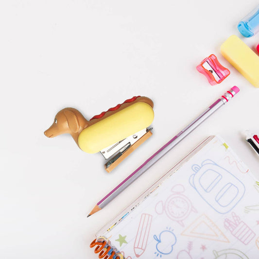 flat lay of hot dog stapler on desk with other office supplies for scale 