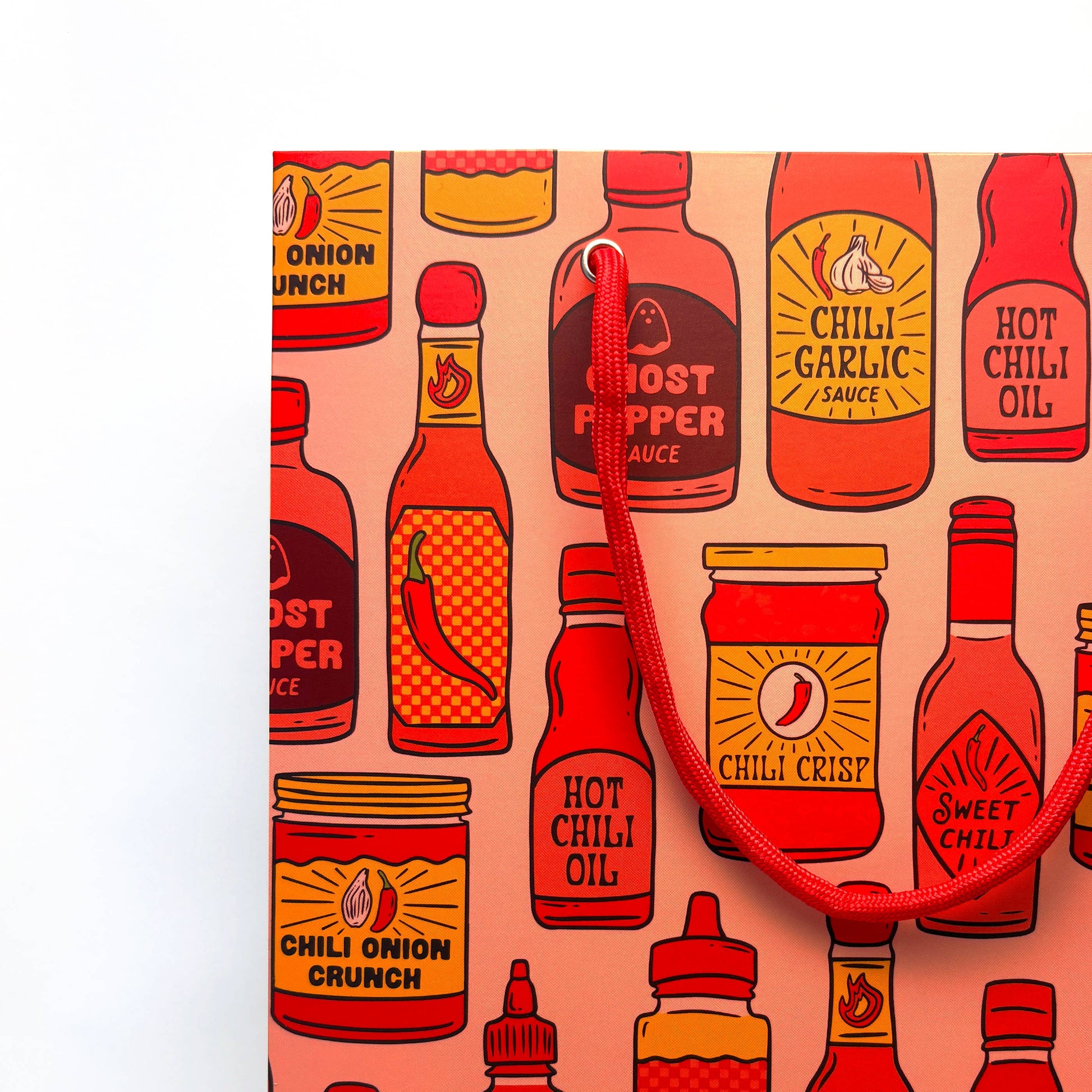 Pattern of hot sauce bottles and jars on a pink background with a red strap.
