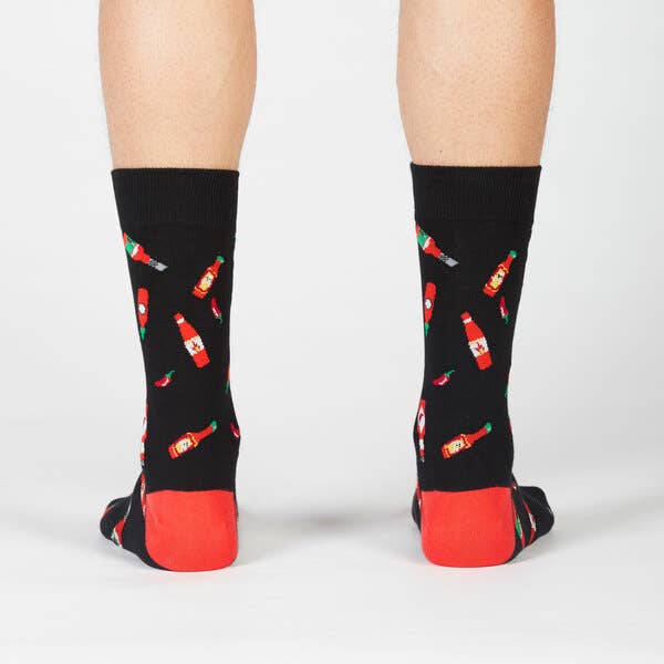 black crew socks with red heels. design has bottles of hot sauce and chili peppers all over 