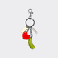Keychain with heart, letter "i" , and pickle charms on a light gray background