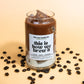 Glass of iced coffee with coffee beans on a beige background