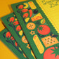 Italian themed grocery list notepad featuring various italian food ingredients including olives, tomatoes, pasta, cheese, crackers, peppers and herbs