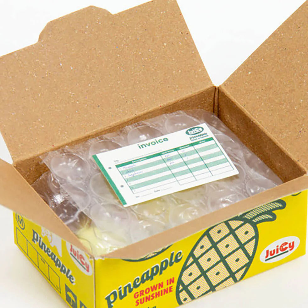 Open cardboard box with a pineapple-themed invoice label
