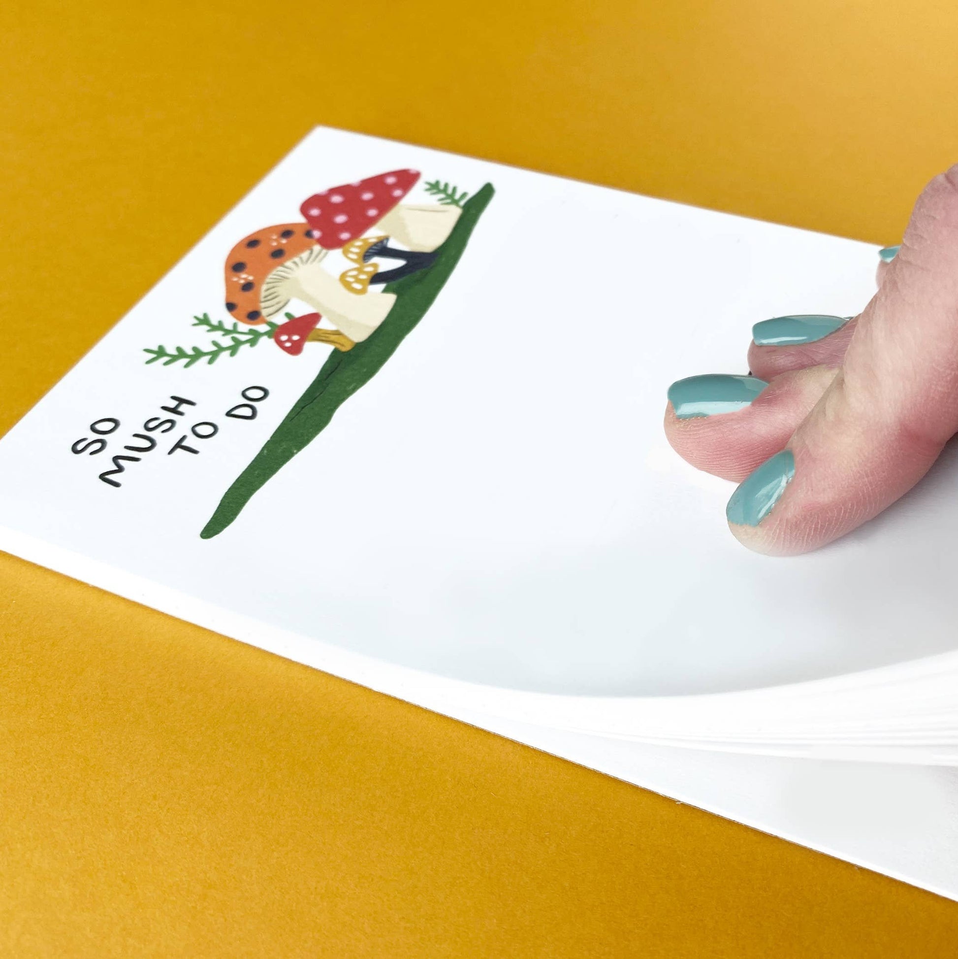a hand flipping through the "so mush to do" notepad 