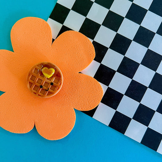 mini smiley faced waffle magnet with a heart-shaped pad of butter and syrup on it