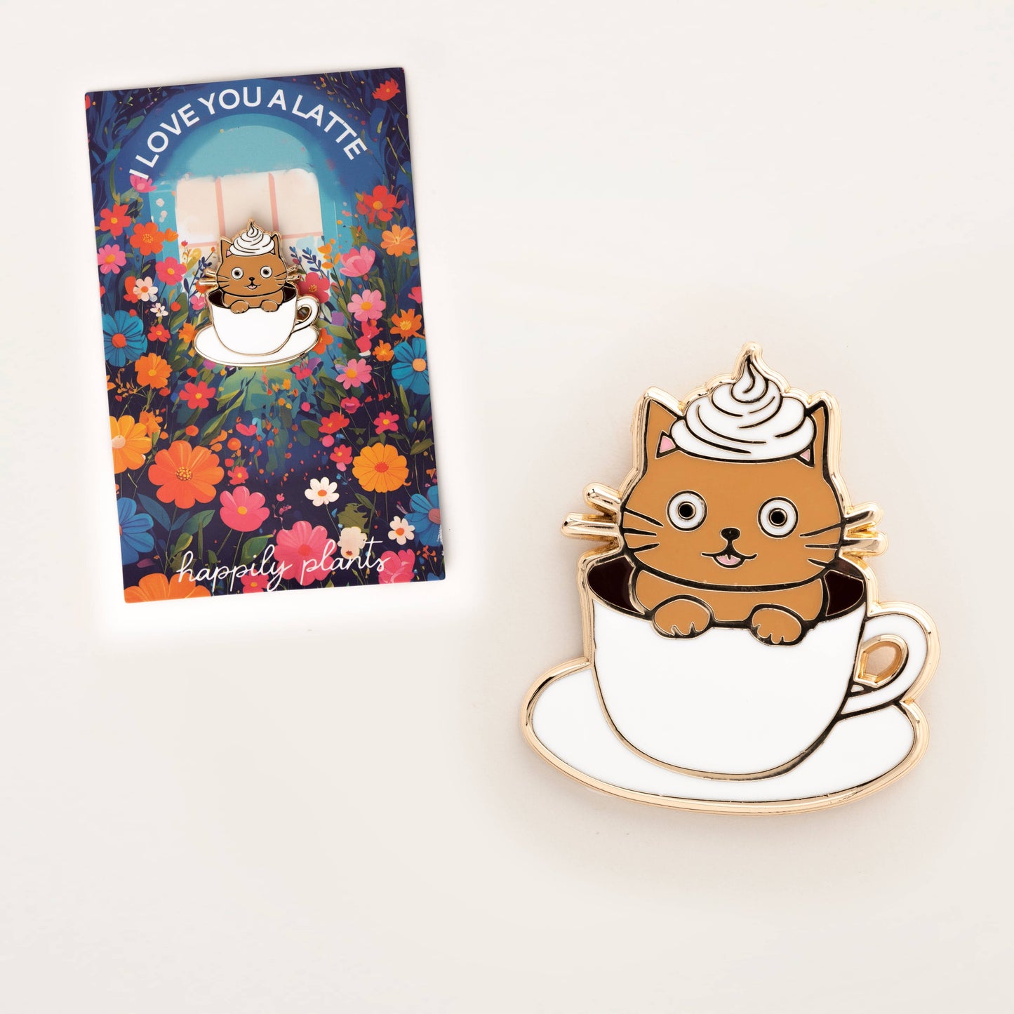 Cat-shaped pin in a coffee cup with a colorful card featuring a cat and coffee design.
