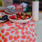 Close up photo of table setting featuring strawberries tea towel draped underneath a bowl of actual fresh strawberries.