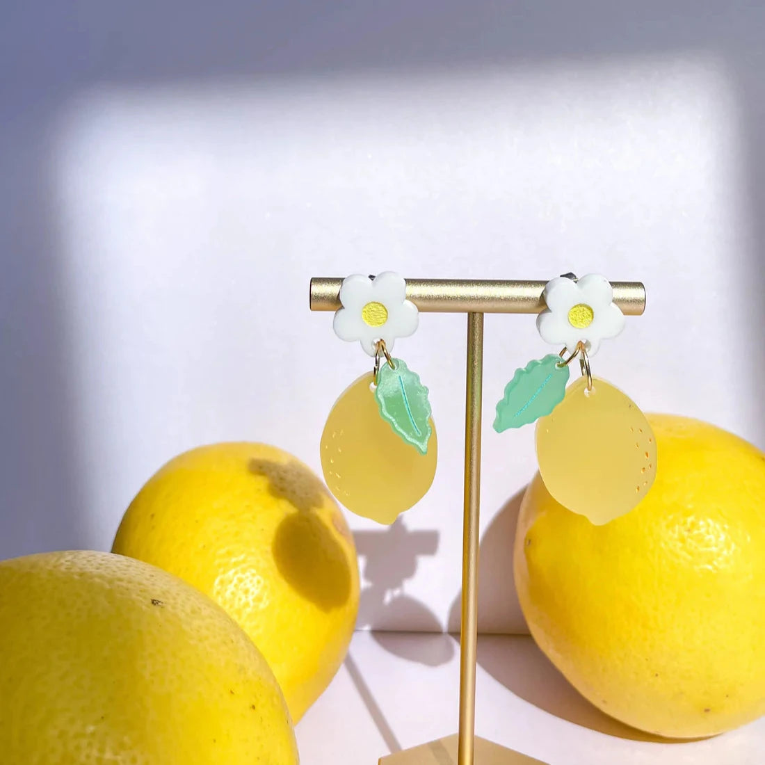 Lemon daisy earrings on jewelry stand 