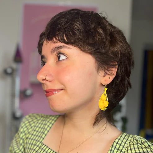 Lemon mesh bag earrings worn on person 