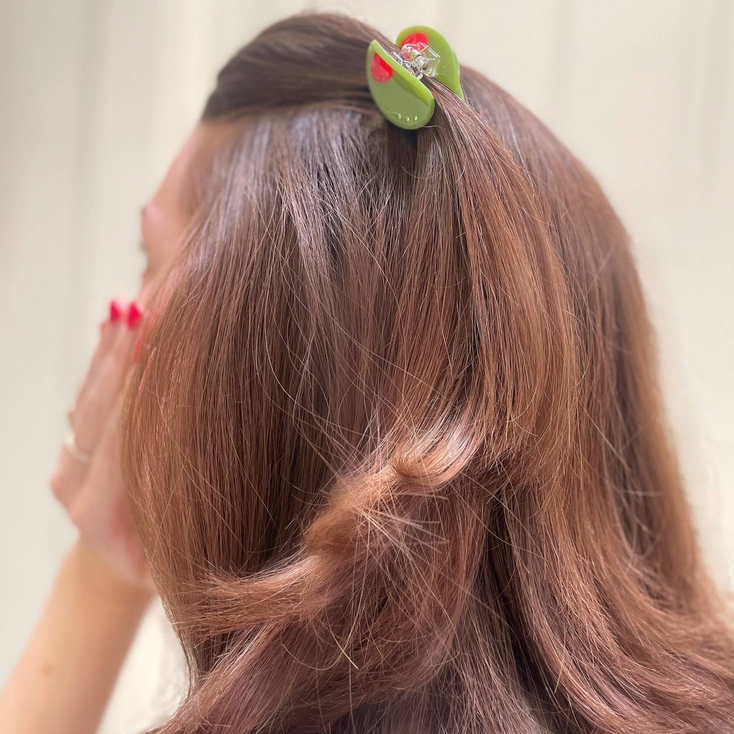 mini olive hair claw holding hair 