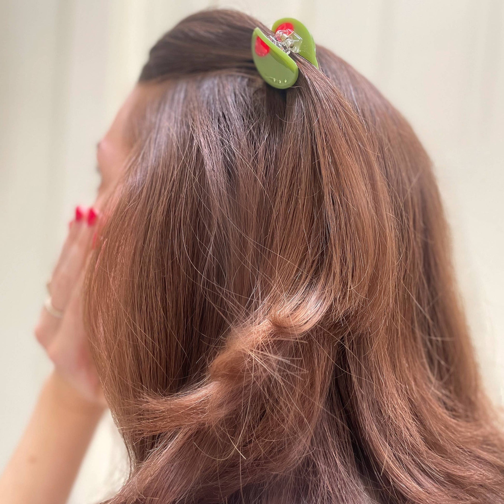 mini olive hair claw holding hair 