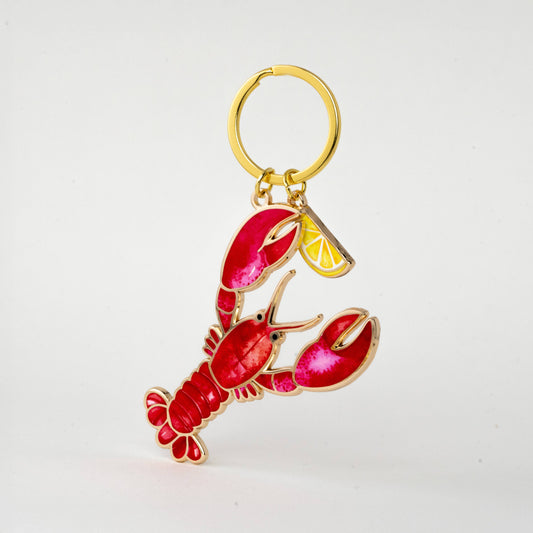 Red lobster with lemon wedge keychain with a gold ring on a white background