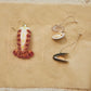 lobster tail glass ornament alongside a clam and mussel ornament 