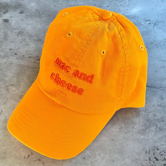 Orange hat with orange embroidery that reads: mac and cheese