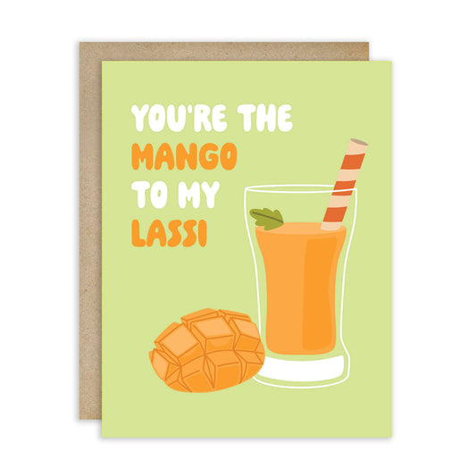 Greeting card with a cut mango and glass of mango lassi on a green background. Text reads "You're the mango to my lassi" 