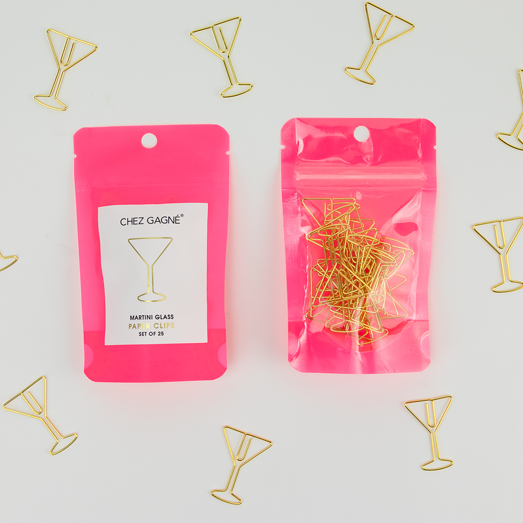 Pink packaging of Chez Gagne martini shaped gold paper clips on a light gray background.