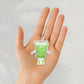 hand holding a sticker of an iced matcha character 
