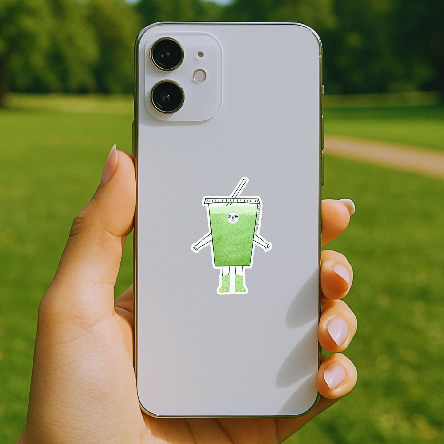 sticker of cartoon iced matcha character on back of phone 