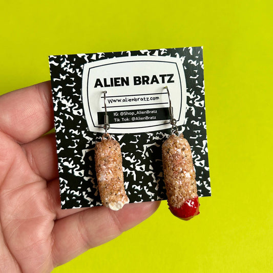 Alien Bratz mozzarella stick earrings on a branded card against a bright yellow background