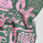 Green fabric with pink abstract mushroom patterns on a towel with a white background