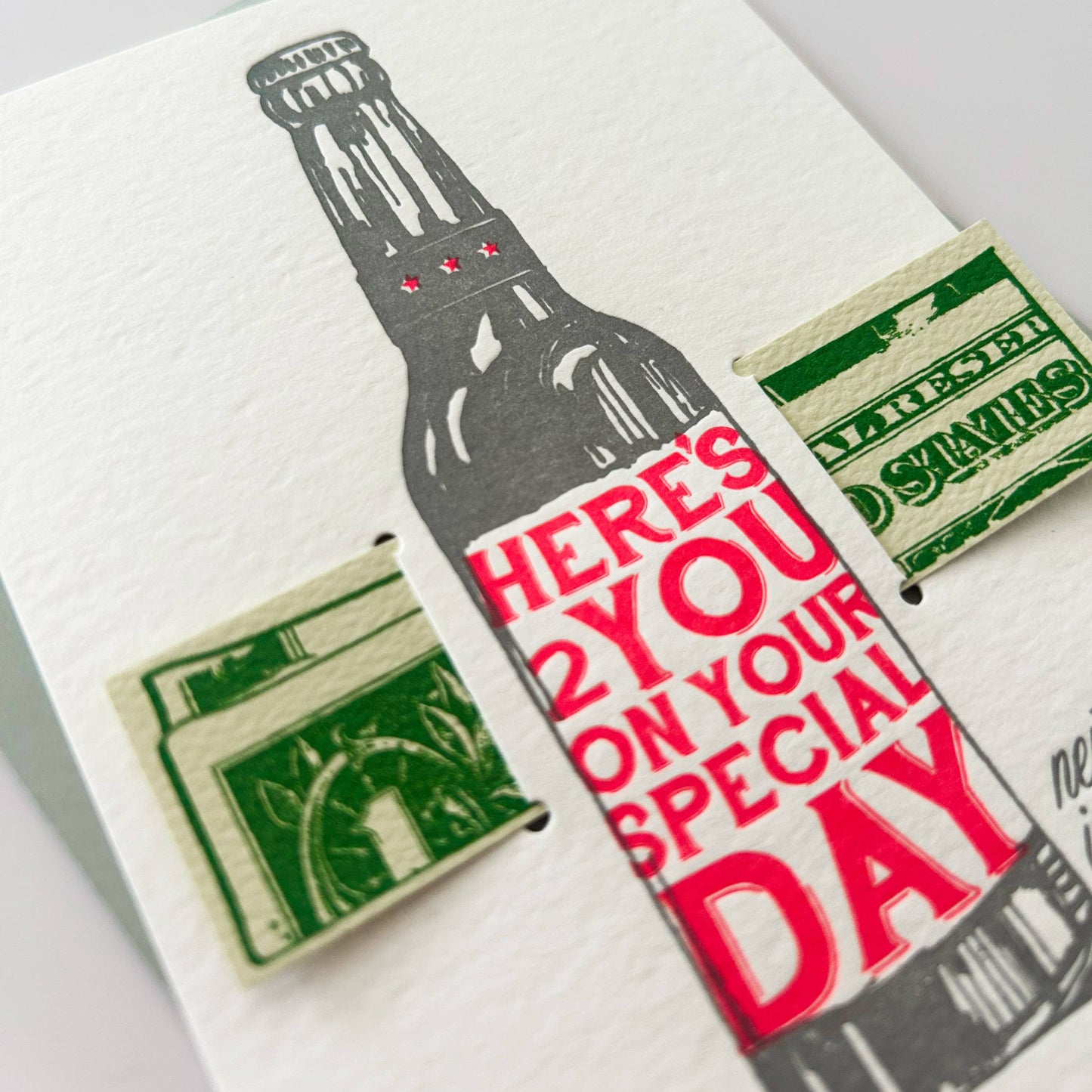 Card with bottle graphic and text 'Here's 2 you on your special day' on a white background