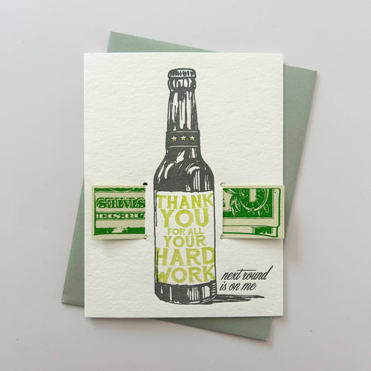 Greeting card with a bottle illustration and text on a gray background with a slot to slip in some dollars