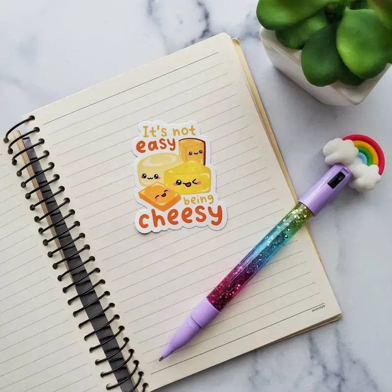 Notebook with a colorful pen and a sticker on a marble surface