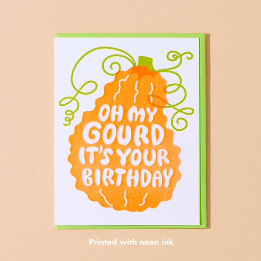 Greeting card with pumpkin design and text 'Oh my gourd it's your birthday' on a beige background.