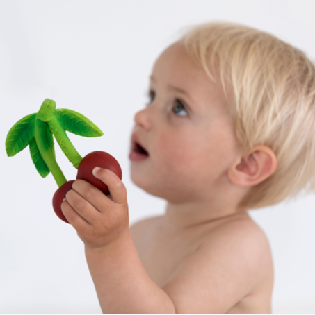 image of a baby holding the cherry teething toy 