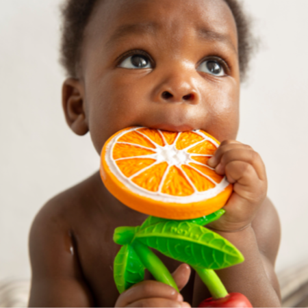 baby chewing on the orange slice baby teething toy 