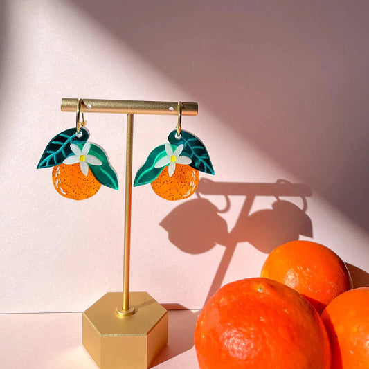 acrylic orange dangle earrings on jewelry stand 