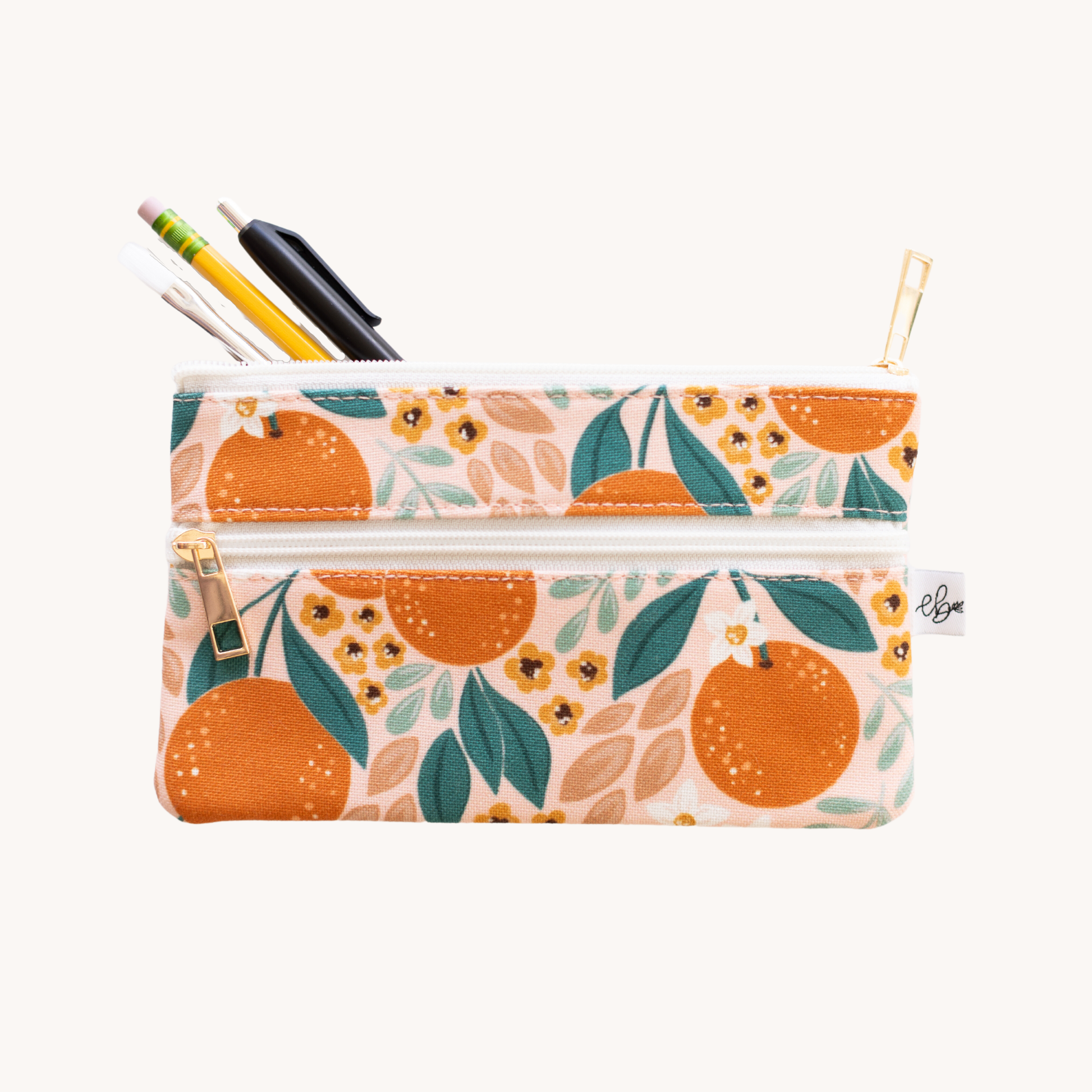 pencil pouch with an orange design by elyse breanne design -- pencil, pen and small paintbrush coming out of top zipper 