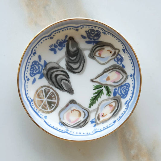 Decorative plate with oyster shells and lemon slices on a white background