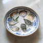 Decorative plate with illustrations of oysters and lemon on a marble surface