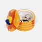 Ceramic storage jar made to look like a stack of pancakes with a decorative lid with a pad of butter and blueberries on a white background