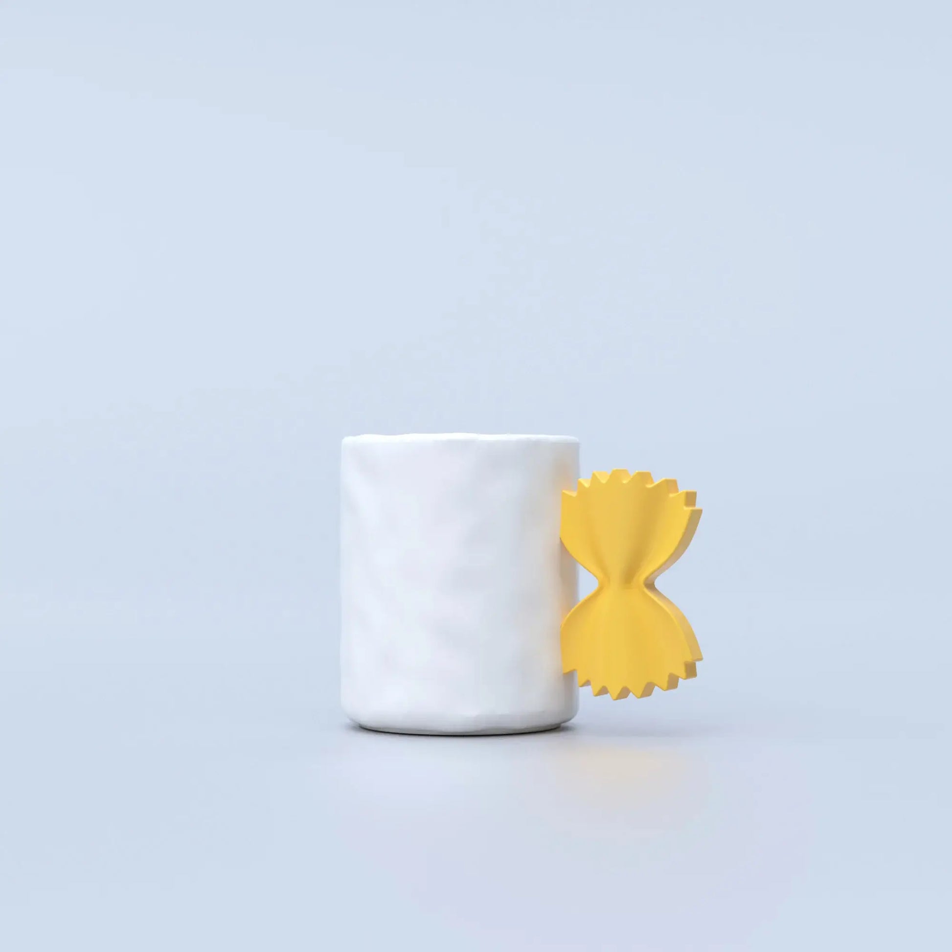 white, ceramic mug with a yellow handle shaped like farfalle pasta 