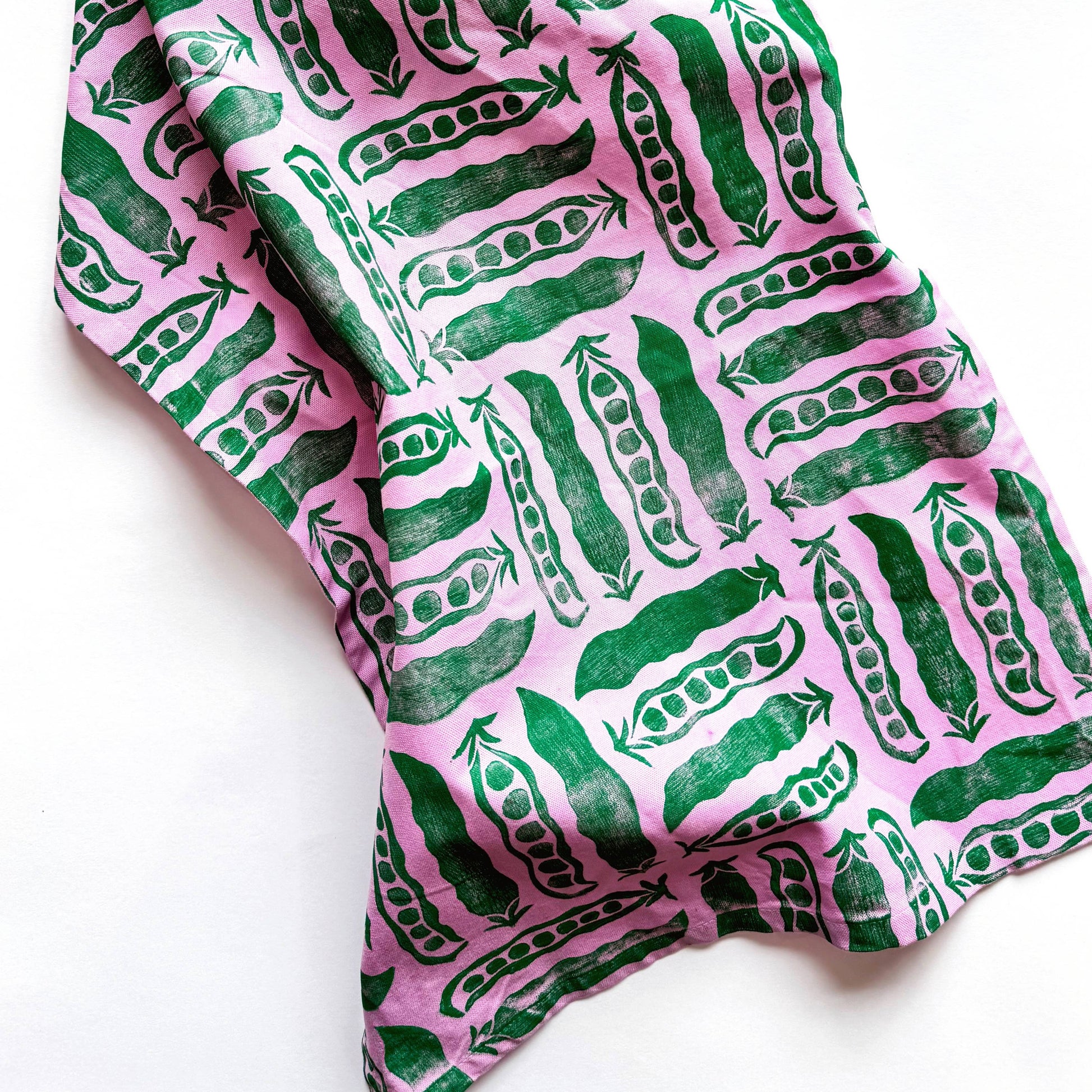 Fabric with green pea pattern on pink background