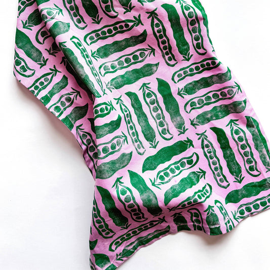 Fabric with green pea pattern on pink background