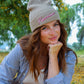 gray knit beanie with "pecorino" stitched across the front, worn on model 