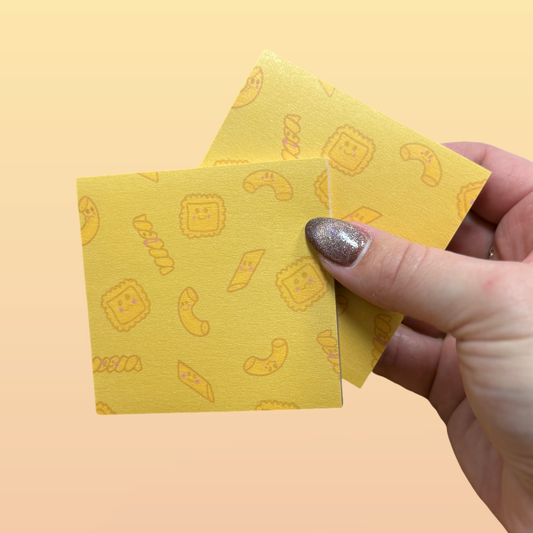 Hand holding two yellow sticky notes with a pasta pattern on a yellow background