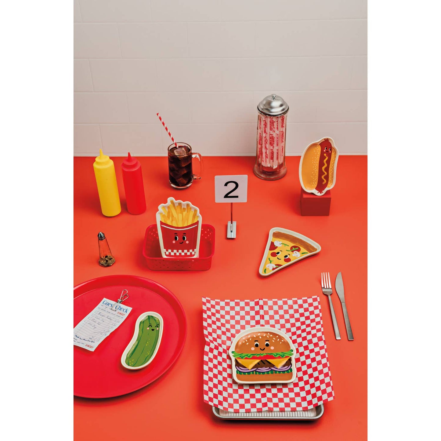 Table setting with fast food-themed items on a red tablecloth