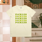 White t-shirt with 'PICKLES' text in green on a kitchen background
