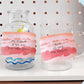 Clear glass jar and mug with memo notes that look like slices of pork belly on it 